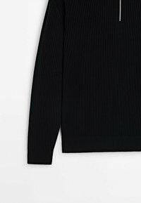 Black ribbed long-sleeve top featuring a high collar and half zipper. The texture is smooth with a horizontal ribbed pattern throughout.