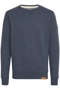 Sudadera azul marino hecha de tejido suave, con cuello redondo, puños acanalados y una pequeña etiqueta de cuero de marca en la parte inferior izquierda.