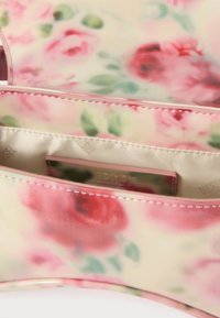 Blomstret taske med en blank finish. Overvejende pink med rosemønstre og grønne detaljer. Indvendigt ses beige foring og branding.