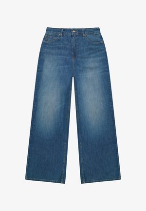Blauwe jeans met wijde pijpen en vervaagde look, vijfzakkenmodel, knoopsluiting en riemlussen, plat uitgestald op een witte achtergrond.