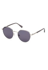 Gafas de sol con lentes redondos y oscuros, marco de metal plateado y brazos negros. Presentan un diseño minimalista y almohadillas nasales ajustables.