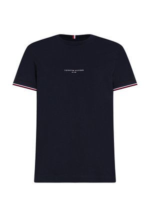 Tumesinane puuvillane T-särk, millel on ümar kaelus, lühikesed varrukad ning kontrastsed punased ja valged triibud varrukatel. Logo on keskel ees.