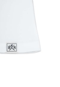 Hvid bomulds-t-shirt med rund hals, forsynet med et trykt sort mærke med "BXR" og krydsede linjer ved kanten. Glat tekstur.