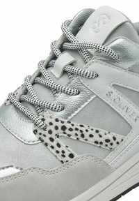 Szürke sneaker ezüst fémes részletekkel, foltos szőrme díszítéssel és mintás fűzőkkel. A dizájn tartalmaz egy márkajelzésű oldal logót.
