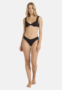 Svart bikini-set med texturerad tyg, bh med byglar och breda axelremmar, samt midjehöga trosor med en sömlös design.