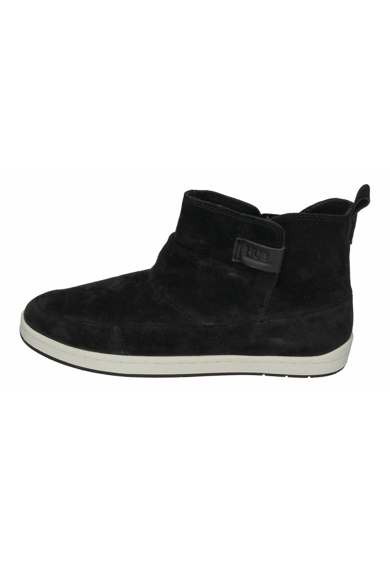 Black suede ankle boot with a rounded toe, white sole, and a side strap featuring a logo. Smooth texture with a mid-height design.