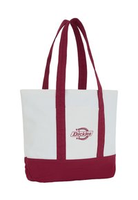 Torba na ramię z płótna, z bordowymi uchwytami i dnem, białym korpusem oraz logo Dickies na centralnej kieszeni z przodu.