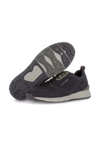 Zapatillas negras de ante con una suela texturizada gris, que presentan un diseño de cordones, un collar acolchado y un detalle de logo en el lateral.