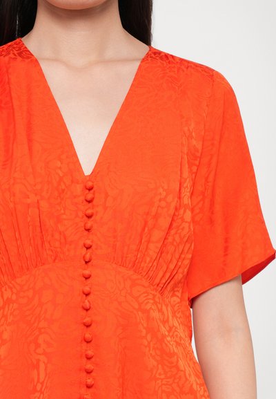 Felgekleurde oranje jurk met een V-hals, korte mouwen, textuurstof en acht knoopdetails aan de voorkant. Glad afgewerkt met geplooide zijkanten.
