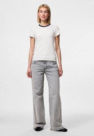 Hvit kortermet t-skjorte med marineblå ribbekrage, kombinert med lysegrå vide jeans. Stoffet ser mykt ut med en jevn tekstur.