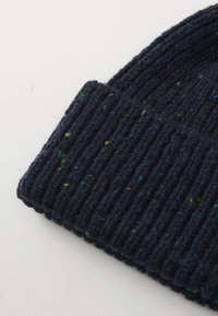 Dark navy blue ribbed knit beanie with multicolored specks on a plain white background.