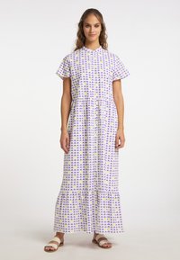 Rochie din țesătură ușoară cu fundal alb, având un model geometric violet și galben, cu mâneci scurte și tiv stratificat.