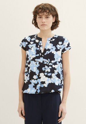 Blumenbluse in Marineblau mit hellblauen und weißen Mustern. Kurze Ärmel, V-Ausschnitt und weicher, glatter Stoff. Lockere Passform.