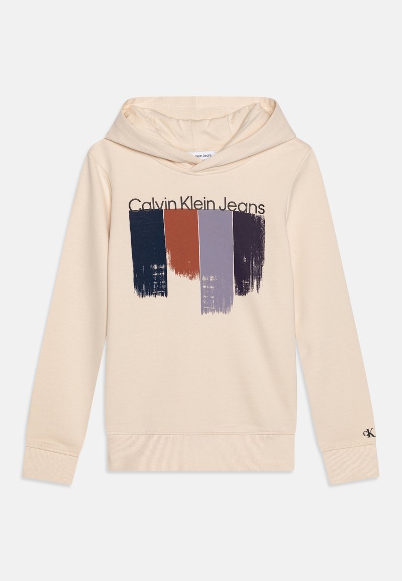Sweat à capuche beige avec cordon de serrage, présentant un motif graphique en coups de pinceau bleu marine foncé, rouille, violet et gris au-dessus du texte "Calvin Klein Jeans". Mélange de coton.