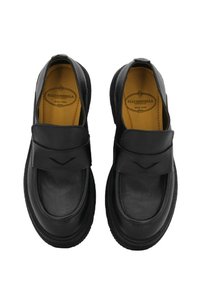 Scarpe in pelle nera con punta arrotondata e una larga fascia sulla parte anteriore. Fodera interna morbida e suola texturizzata per grip e comfort.