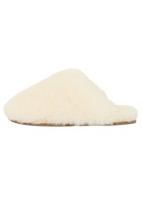 Fuzzy crème pantoffel gemaakt van zacht materiaal met een ronde neus en een platte tan zool; eenvoudig ontwerp zonder versieringen.