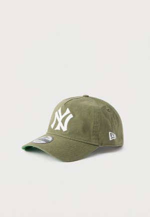 Olivgrön bomullskeps med en vit, broderad New York Yankees-logotyp, böjd skärm och en liten logotypdetalj på sidan.