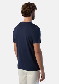 T-shirt a maniche corte blu navy realizzata in tessuto morbido, con un design classico, colletto rotondo e vestibilità regolare. Stile minimalista.