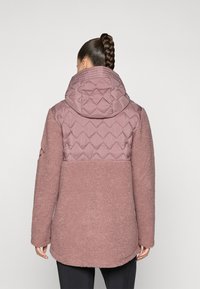 Padded jacket in mauve, featuring a diamond quilted upper panel and soft, textured fleece lower section. Hooded design with long sleeves.