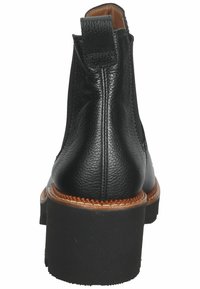 Botín negro de cuero hasta el tobillo con un acabado texturizado, que cuenta con un tacón robusto, punta redondeada y un detalle de costura visible.