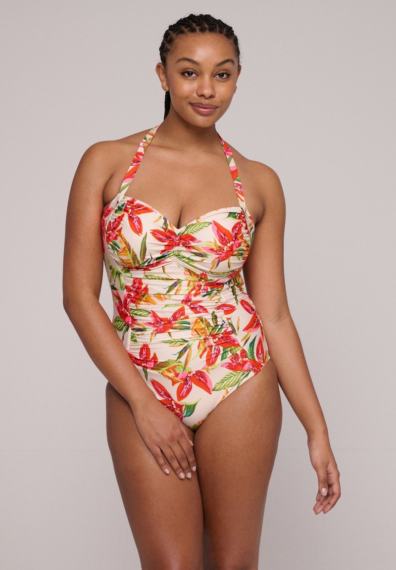 Bañador de una pieza hecho de tela elástica, con un estampado floral en tonos rojos y verdes sobre un fondo beige claro. Escote halter.