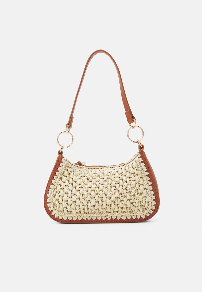 Pequeño bolso de mano con panel frontal de tejido en color crema, ribete de cuero marrón, anillos dorados circulares y una sola correa de cuero marrón para el hombro.