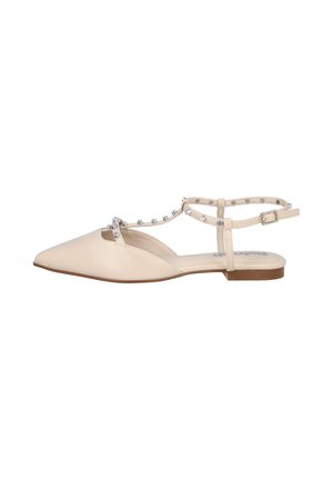Sandalia plana beige de punta con correa en el tobillo, tachuelas plateadas a lo largo de la correa en T y tacón bajo marrón.