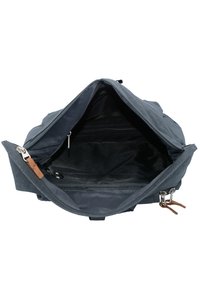 Grijze canvas tas met een ritssluiting, die een zwart interieur onthult. Bevat leren accenten en een sleutelhanger bevestiging.
