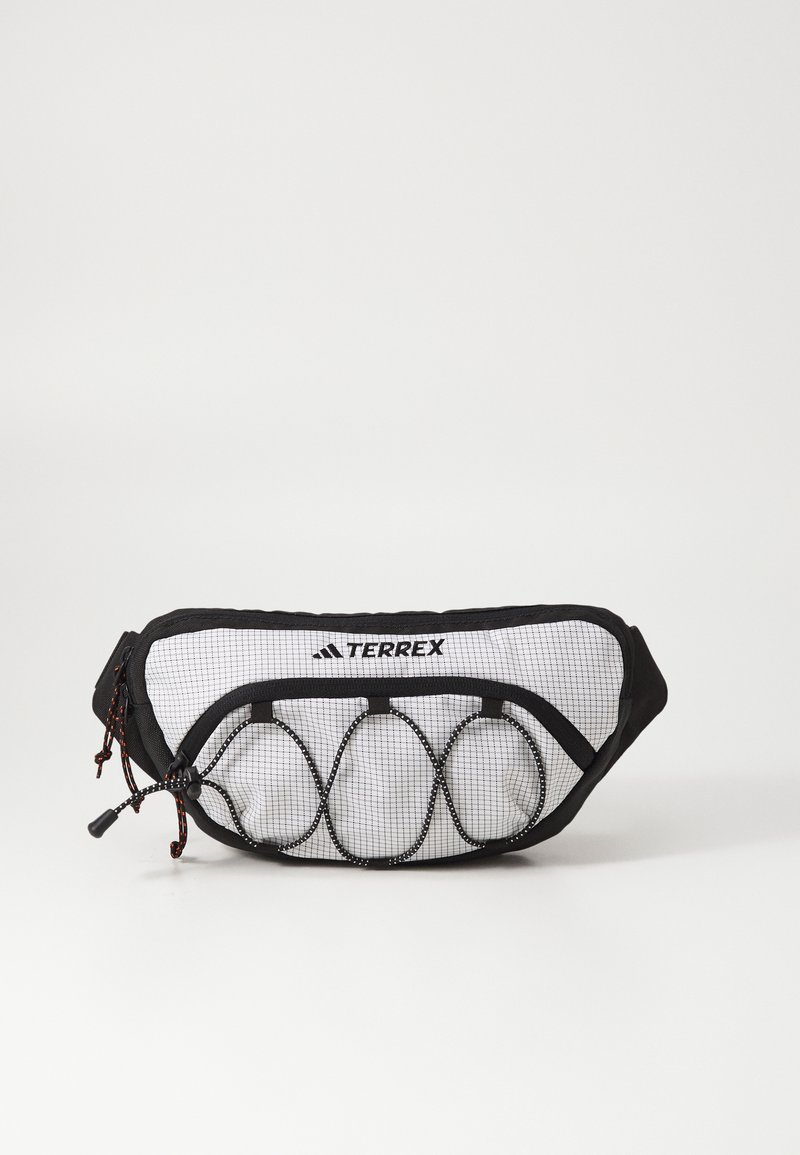 Bolsa de cintura preta e branca com detalhes em malha, cordão ajustável e forma curvada. Apresenta um logo TERREX em destaque na parte da frente.