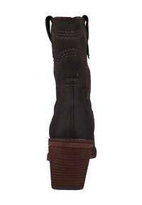 Bota de tobillo de cuero marrón con tacón apilado, costuras claras y lengüetas. Presenta una costura bien definida y una textura suave.