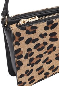 Tasje met luipaardprint en een leren rand in zwart, voorzien van gouden ritshardware, met een zachte, gestructureerde oppervlakte.
