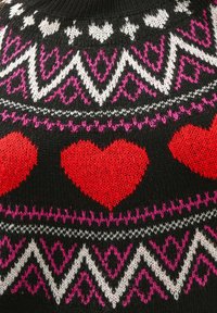 Pull en tricot noir avec des cœurs rouges et des motifs géométriques en blanc et rose. Col roulé avec une texture douce.