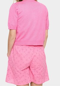 Vibrantti vaaleanpunainen neulottu lyhythihainen paita ja yhteensopivat shortsit kukkakuosisella ristipisto-ompeleella ja sivutaskuilla, joustava vyötärö ja pehmeä rakenne.