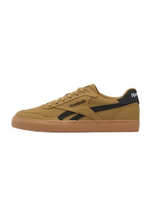 Sneaker marrone Reebok low-top con suola in gomma e striscia nera laterale, mostrata di lato su sfondo bianco.