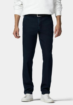 Dunkelblaue Denim-Hosen mit geradem Bein, ausgestattet mit Gürtelschlaufen und klassischem Fünf-Taschen-Design. Getragen mit weißen Sneakers.