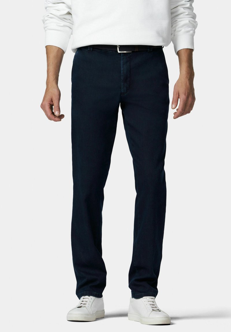 Pantalons en denim bleu marine avec une coupe droite, dotés de passants de ceinture et d'un design classique à cinq poches. Portés avec des baskets blanches.