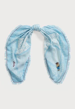 Sky blue scarf with fringe edges, featuring intricate white patterns and a small embroidered figure on one side.