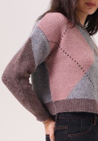 Pull en maille avec des motifs géométriques en gris, rose clair et marron foncé. Design court avec un ourlet côtelé et des manches texturées.