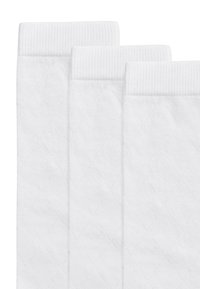 Weiße Baumwollsocken mit einem gerippten oberen Rand und einem Rautenmuster auf dem Stoff, präsentiert in einem Set von drei.