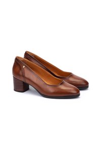 Chaussures à talon bas pour femmes en cuir marron, avec un bout arrondi et un détail de contrefort texturé, présentées côte à côte sur fond blanc.