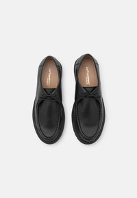 Zwarte leren schoenen met een ronde neus en minimale stiksel-details. Inclusief een eenvoudig vetersysteem en een gestructureerde zool voor extra grip.