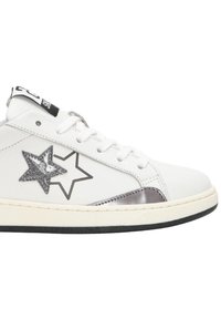 Sneaker bianca in pelle con accenti argentati e neri a forma di stella, dettagli metallici sui lati e lacci bianchi. Suola in gomma con battistrada nero.