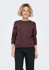 Vinröd stickad tröja med rund halsringning och långa ärmar, som har en mjuk textur och en något kortare fåll.