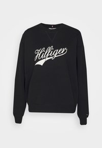 Sudadera negra de algodón, con un logo en cursiva blanco "Hilfiger" en la parte frontal, cuello redondo y puños y dobladillo acanalados.