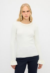 Weißes, geripptes Langarmoberteil mit einem gewellten Ausschnitt, verziert mit Perlenakzenten an den Manschetten, mit enganliegendem Schnitt und weicher Textur.