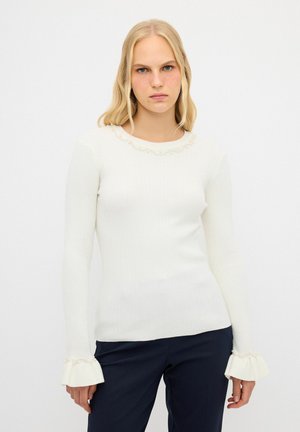 Top à manches longues blanc à côtes avec un décolleté festonné, orné d'accents en perles aux poignets, présentant un design ajusté et une texture douce.