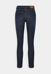 Smala jeans i mörkblå denim, med midjehöjd, fem fickor och en brun läderlogotyp på baksidan. Slät textur.