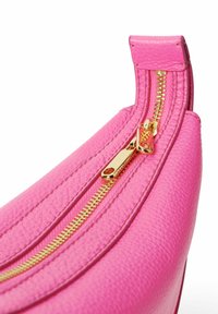 Borsa in pelle rosa con superficie testurizzata, caratterizzata da una zip dorata prominente e un tirazip coordinato. Progettata con una forma arrotondata.