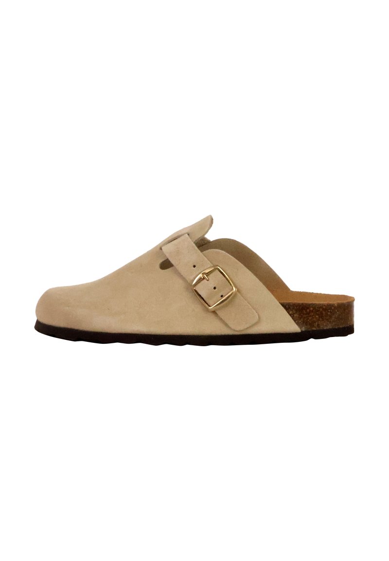 Mocassin en suede beige à enfiler avec une boucle dorée ajustable, semelle intermédiaire en liège brun et semelle extérieure en caoutchouc noir texturé. Design lisse et minimaliste.