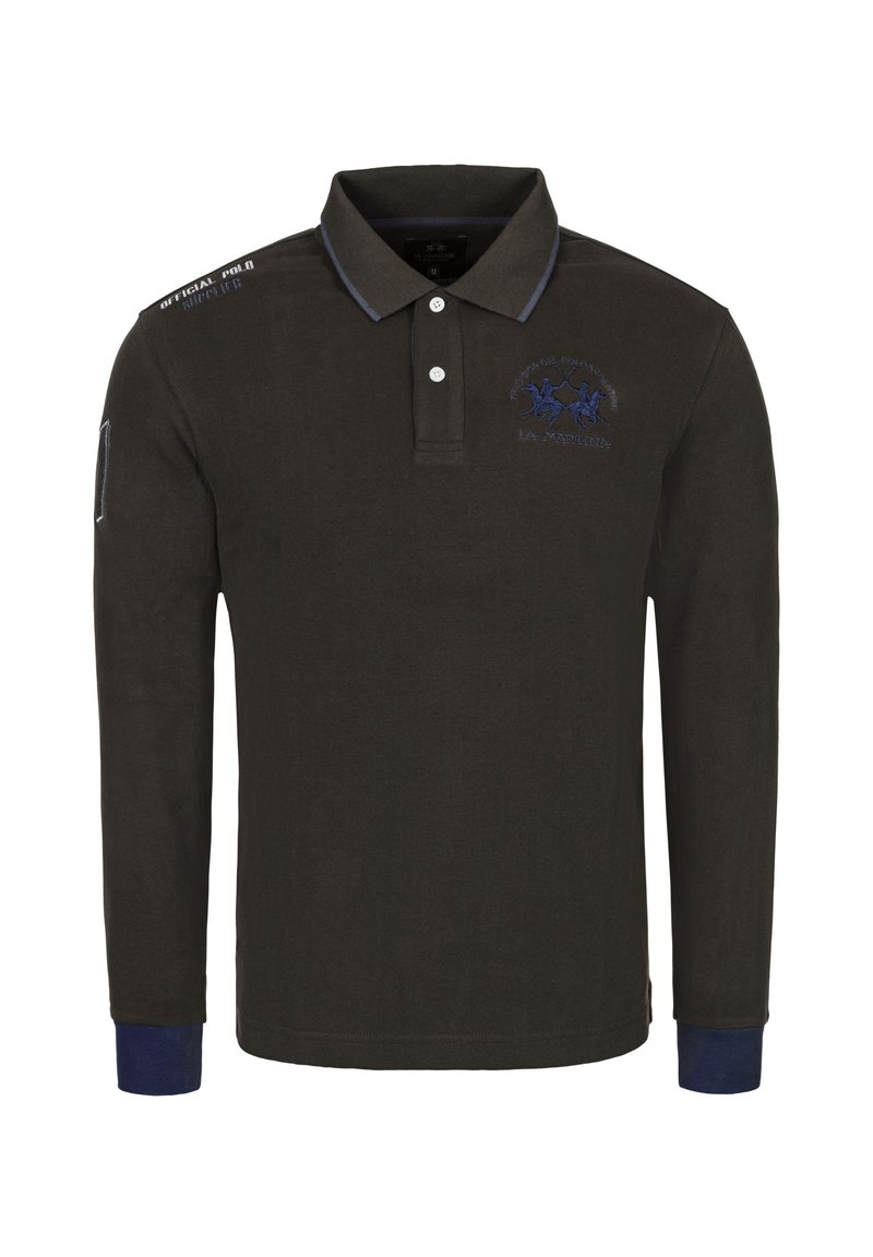 Polokošile s dlouhým rukávem v tmavě zelené látce s žebrovaným límcem, modrými akcenty na manžetách a vyšitým logem na hrudi. Detail kapsy na levém rukávu.